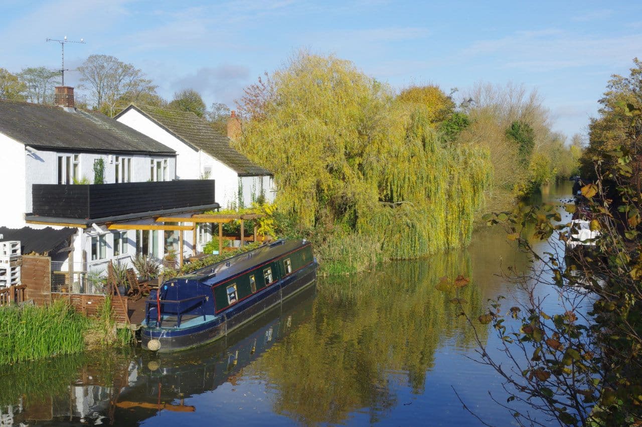 Narrowboat moored on the Grand Union Canal in Leighton Buzzard, willows on the far bank